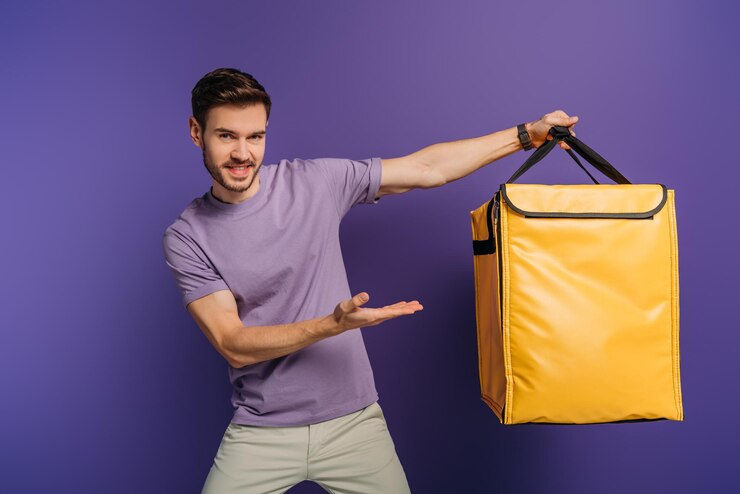 cheerful-delivery-man-pointing-with-hand-thermo-backpack-while-looking-camera-purple_1188894-13446